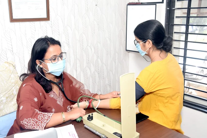 Dr. Anjali Verma checking a patient's blood pressure during a consultation at B Healthy Clinic in Nipania, Indore.